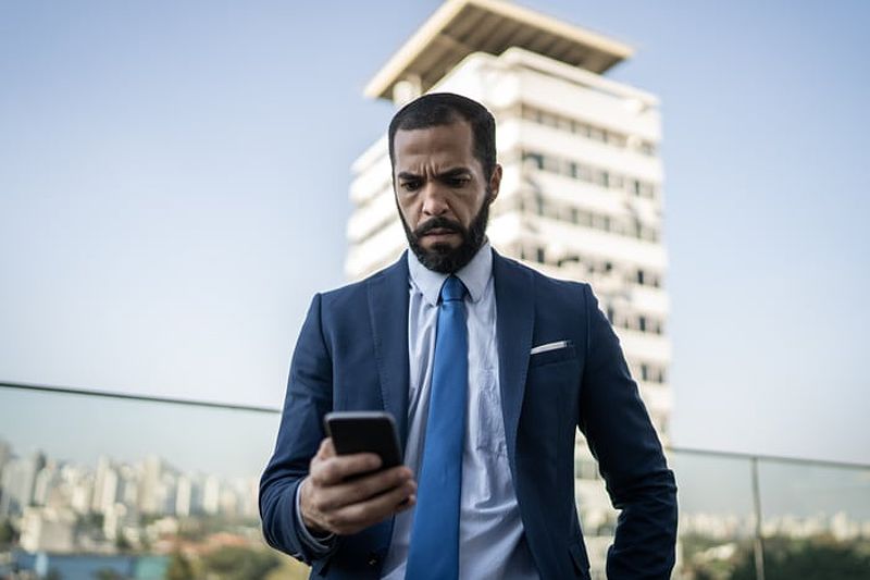 Investor in suit with smartphone